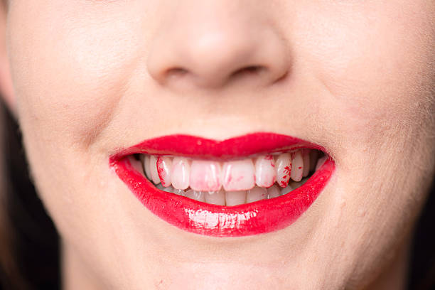 close up mouth and teeth with lipstick Close up of a caucasian face and mouth with red lips and lipstick on her white teeth lipstick on teeth stock pictures, royalty-free photos & images