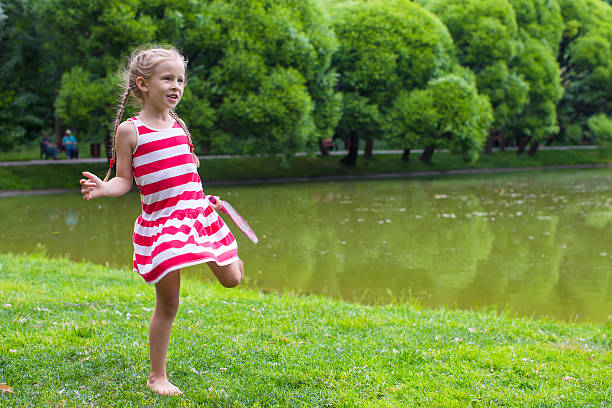 Cute little girl playing badminton on a picnic