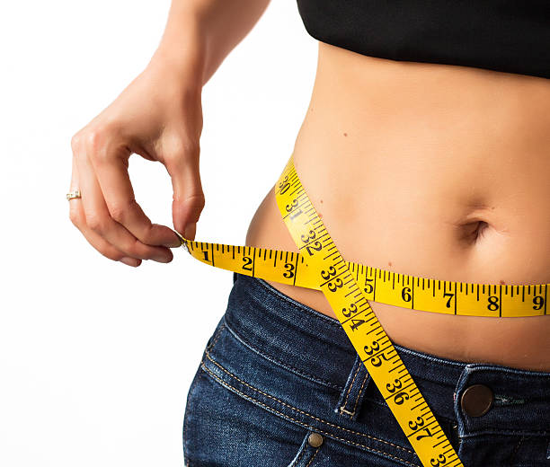 istock Woman showing her waist as she measures it 465940015