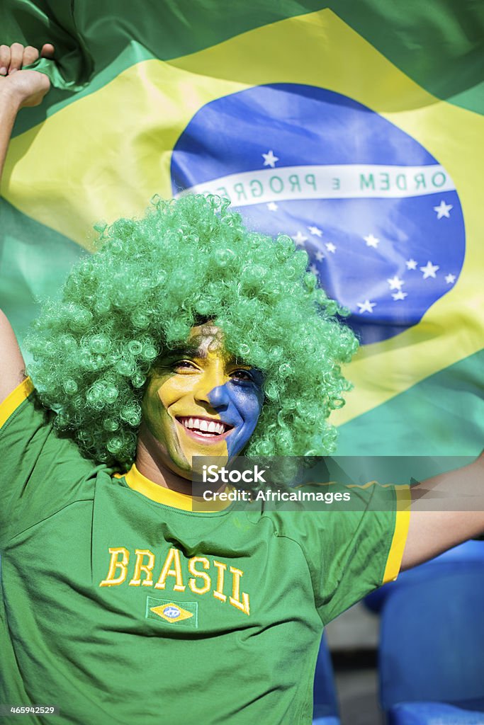 Brazilian football fan waving a flag. Brazilian football fan waving a flag supporting his country. Fan - Enthusiast Stock Photo