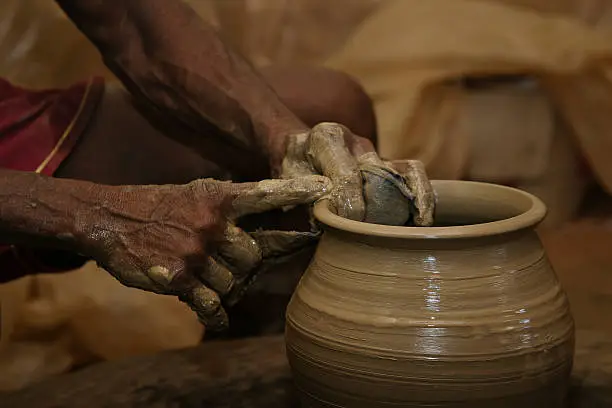 A man from Goa formed on an old flywheel vases and jugs of clay.