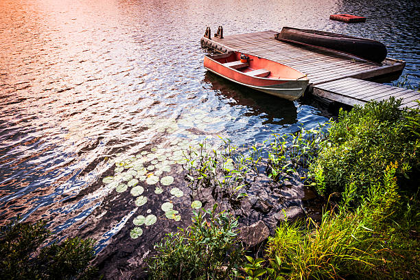 istock Rowboat on lake shore at sunrise 465950789