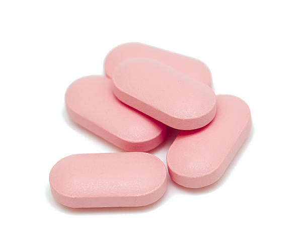 pillen isoliert auf weißem hintergrund - pink pill stock-fotos und bilder