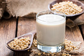 Soy beans on a wooden table with a glass of milk on the side