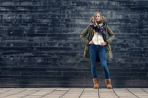 istock Woman in Winter Outfit in Front Old Gray Wall 465957020