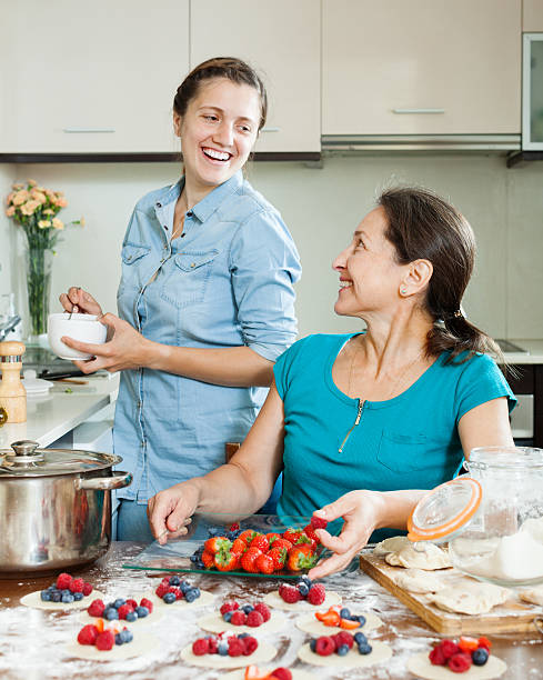 istock Two smiling women making perogies with berries 465959437