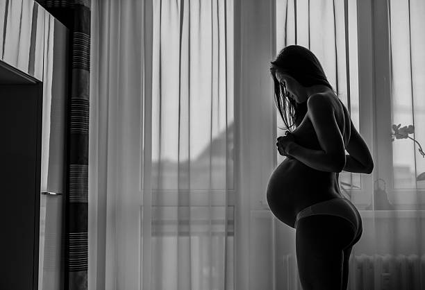 istock pregnant woman looking out the window 465959894