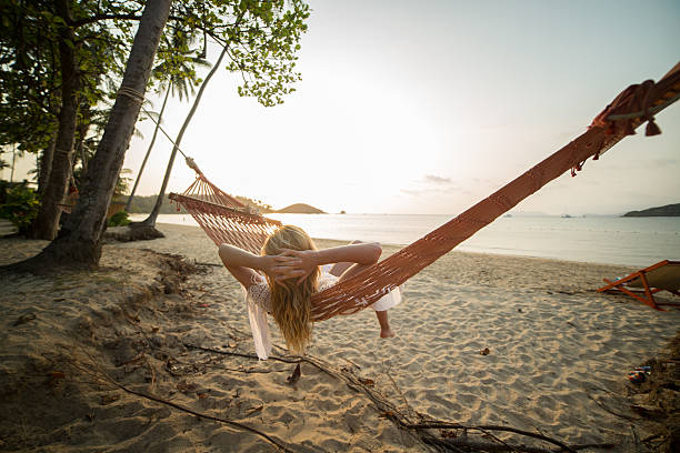 istock Woman watching sunset from hammock-Beach 465961510