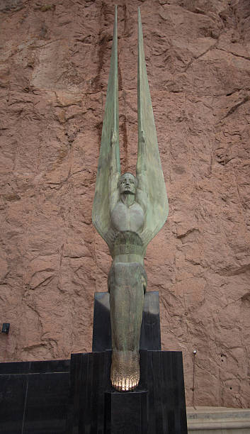 Hoover Dam Statue Boulder City, United States - February 23, 2015: This image shows a metal statue at Hoover Dam, a concrete arch gravity dam on the Colorado River on the border of Nevada and Arizona.  hoover dam statues stock pictures, royalty-free photos & images