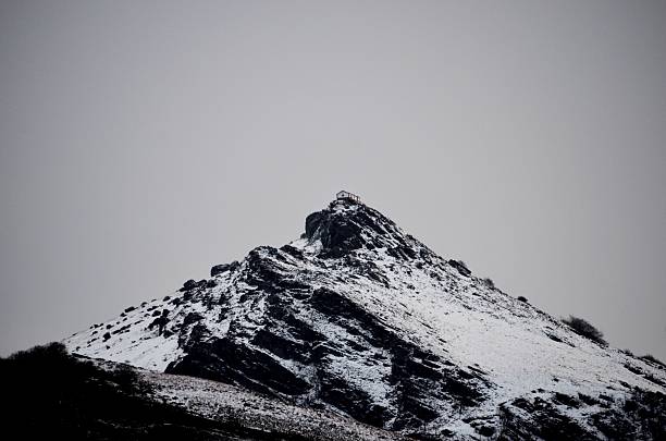 Hiking deep in the winter on the snowy mountains conquering peaks during dramatic weather conditions
