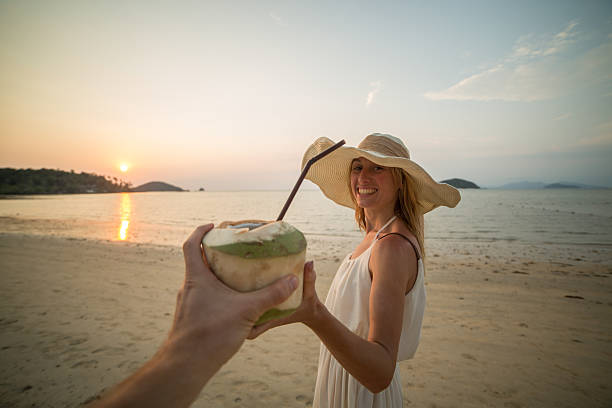 istock Happy couple walking on beach sharing a coconut 465977728