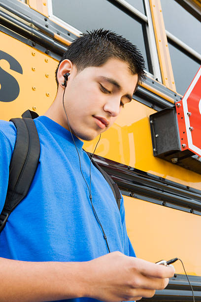 istock Man Listening Music Against School Bus 465978062
