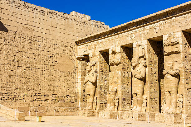 Ancient egyptian statues in the mortuary Temple of Ramses III Ancient egyptian statues in the mortuary Temple of Ramses III rameses ii stock pictures, royalty-free photos & images