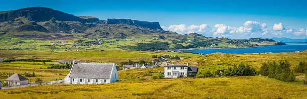 Summer sunlight on the green meadows, crofters cottages and rocky mountains of the Trotternish Peninsula, Isle of Skye, Scotland. ProPhoto RGB profile for maximum color fidelity and gamut.