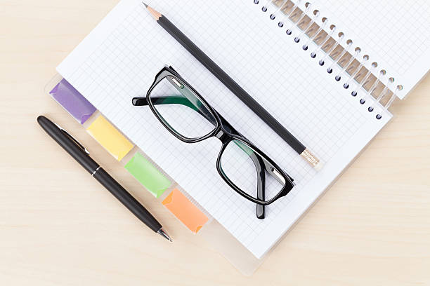 istock Office table with glasses over notepad, pen and pencil 465988690