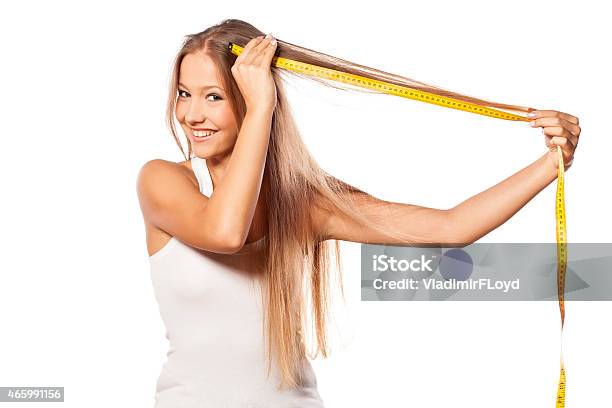 Beautiful Girl Measures Her Hair With A Measuring Tape Stock Photo - Download Image Now