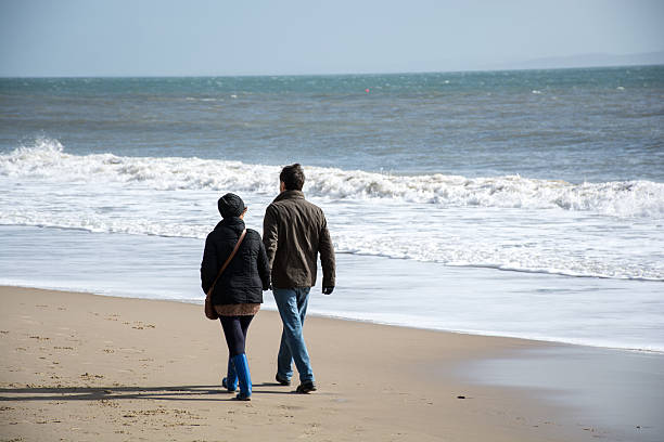 istock Couple stroll along the beach 465992062