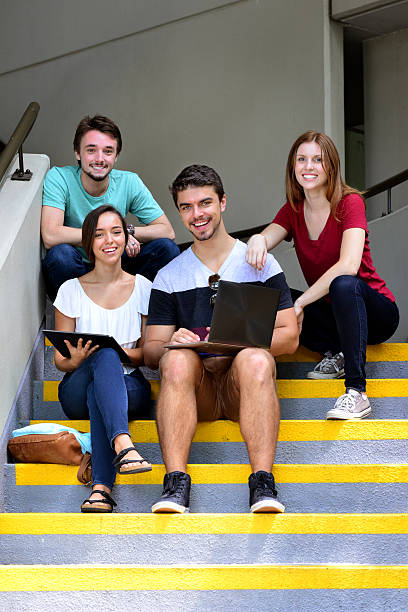 istock Four students relaxing outside on the grounds of a university 465992974