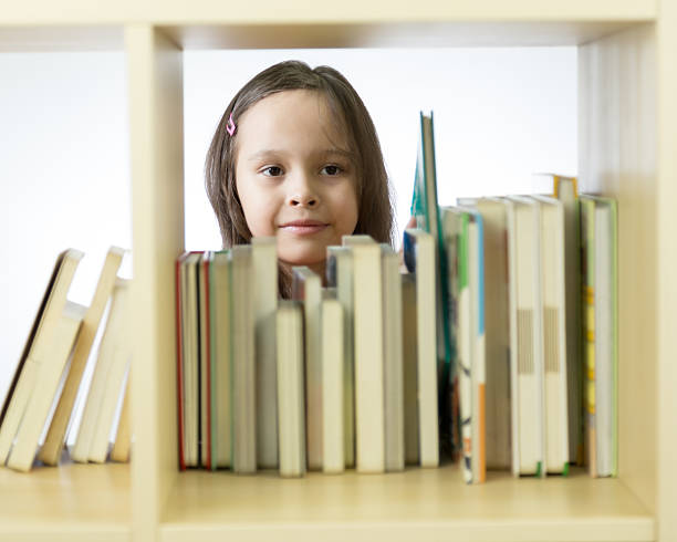 istock Young girl looking at books on bookshelf 465993162