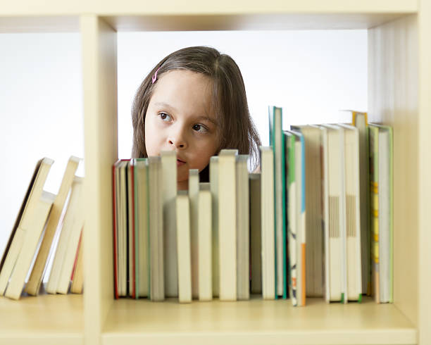 istock Young girl looking at books on bookshelf 465993480