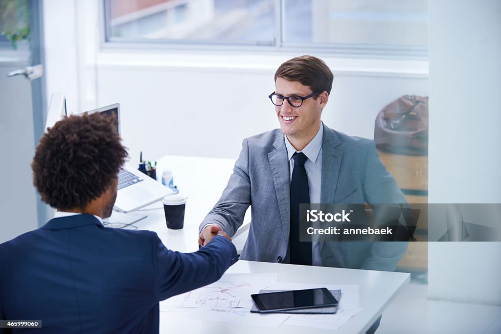 Start the day with some positive interaction Shot of a smiling businessman greeting a colleague with a handshake 2015 Stock Photo