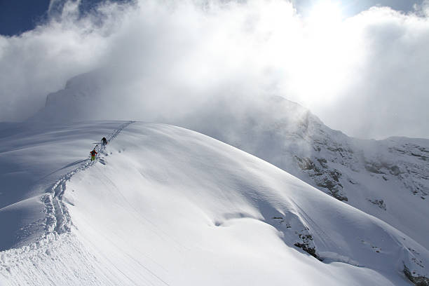 istock Skiers climbing a snowy mountain 466001309