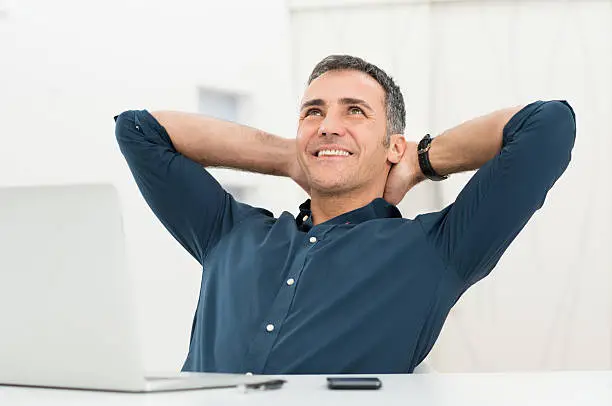 Mature Man Satisfied Sitting In Front Of Laptop Daydreaming