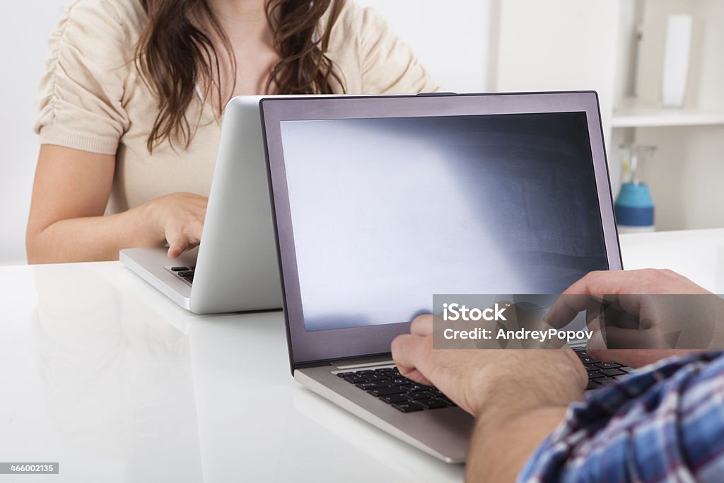 Couple Using Laptop Man Sitting In Front Of Woman Looking At Laptop Adult Stock Photo