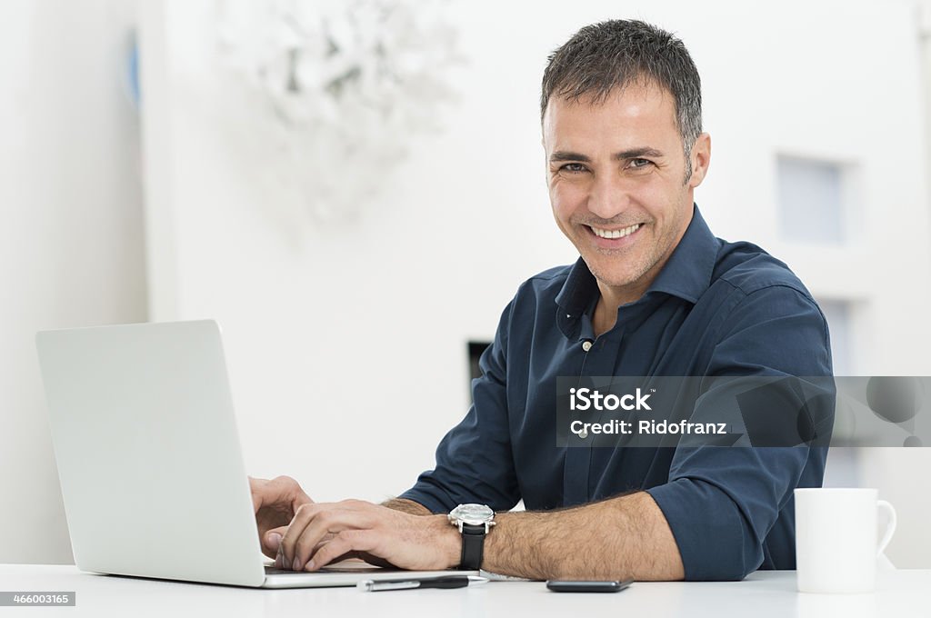 Man Using Laptop At Desk Portrait Of A Happy Smiling Mature Man Using Laptop At Desk Men Stock Photo