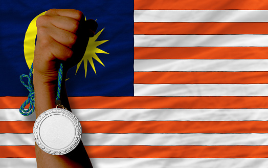 Holding silver medal for sport and national flag of malaysia