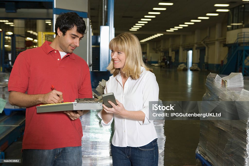 Workers Working In Newspaper Factory Young male and female make inventory in the newspaper factory 2015 Stock Photo