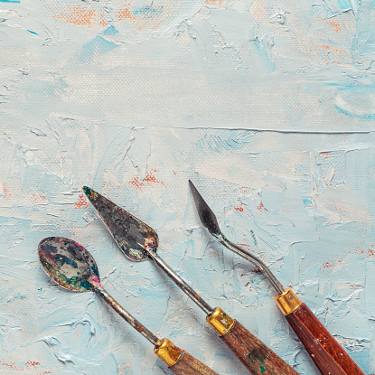 Old palette knifes on artist canvas with oil paint