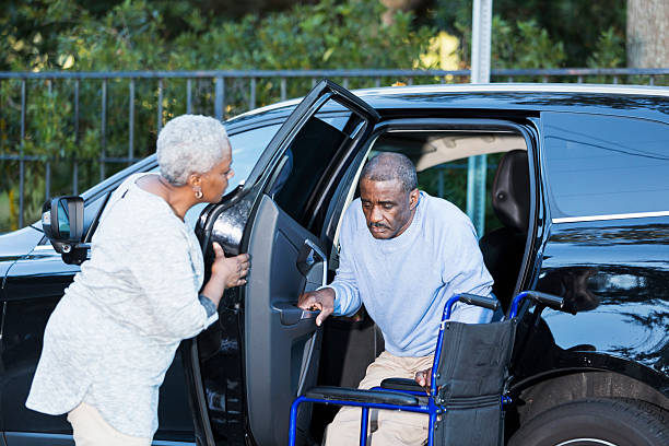 disabili senior uomo guida di auto per sedia a rotelle - couple dependency standing men foto e immagini stock