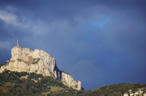 View of Mountain and cross of Nivolet near Chambery, France, under a stormy sky.