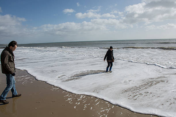 istock Man watching wife walk in water 466006630