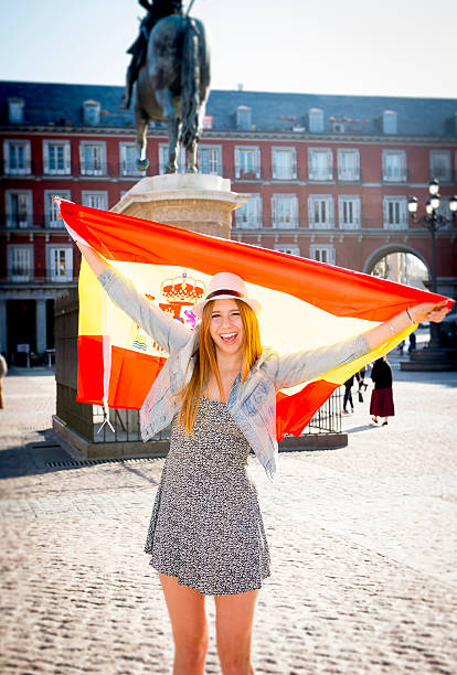 istock young happy attractive exchange student girl showing Spain flag 466007014