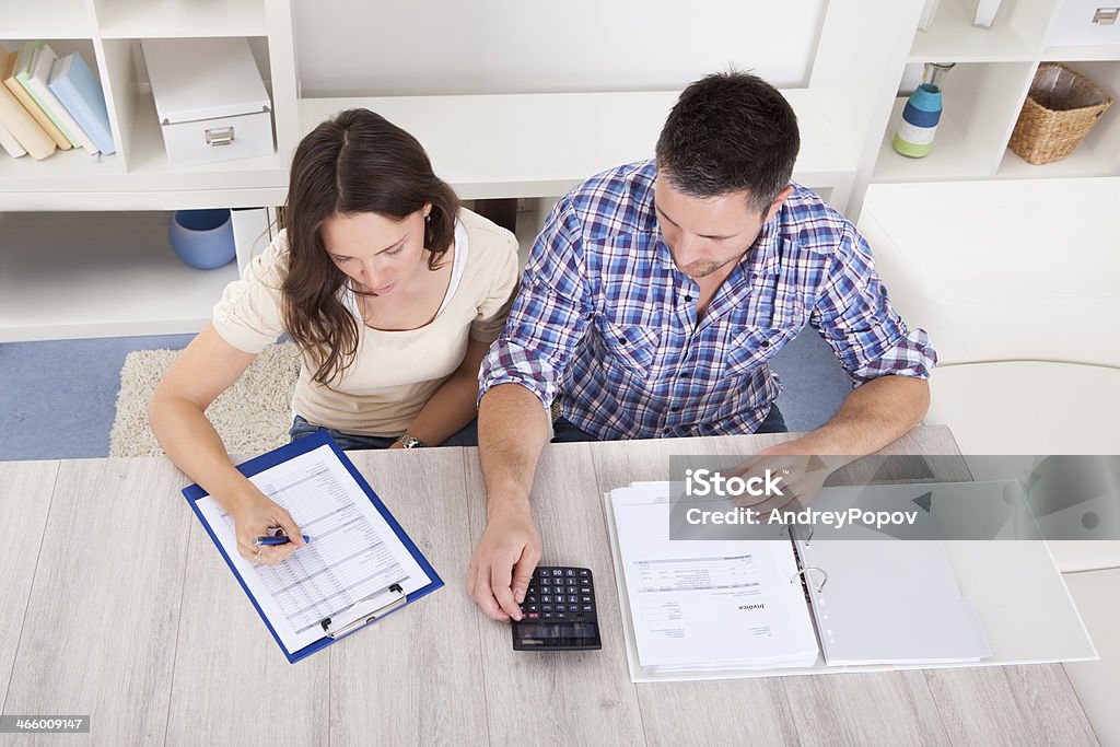 Couple Calculating Bills Portrait Of A Young Couple Calculating Finance At Desk Active Seniors Stock Photo