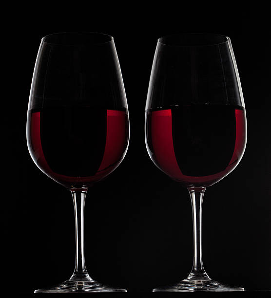istock Two red glasses with wine on black background 466010915