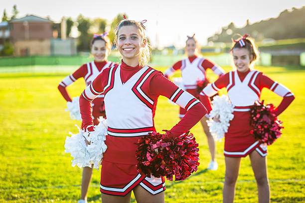 Group of cheerleading girls practicing tricks at training together with coach