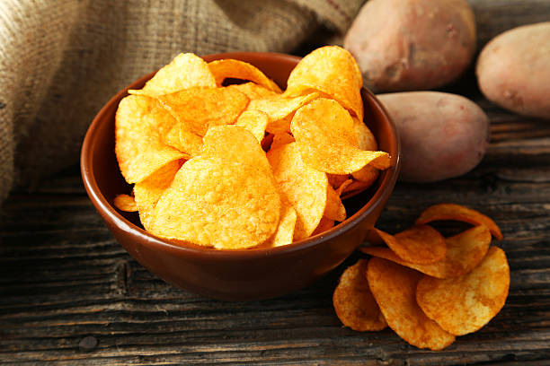 istock Potato chips in bowl on brown wooden background 466011700
