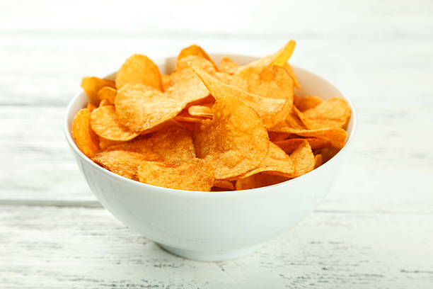 istock Potato chips in bowl on white wooden background 466012036