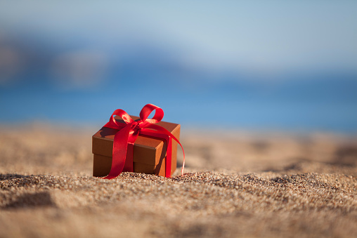 Terracotta color gift box on a beach