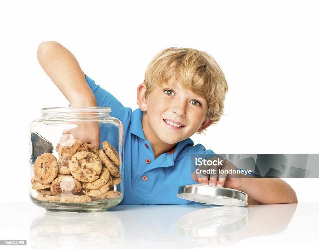 Little Boy prendendo Biscotto con gocce di cioccolato isolato - Foto stock royalty-free di Abbigliamento casual