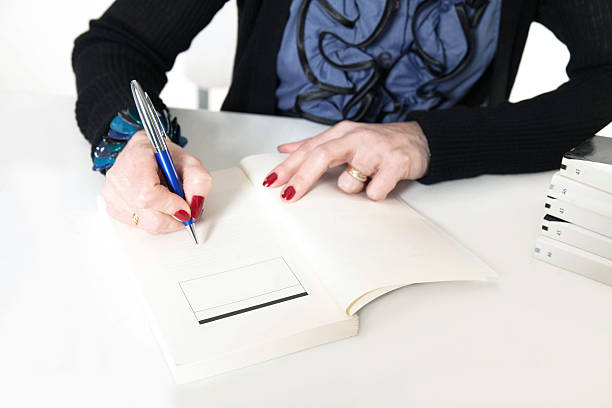 Female writer signing books stock photo