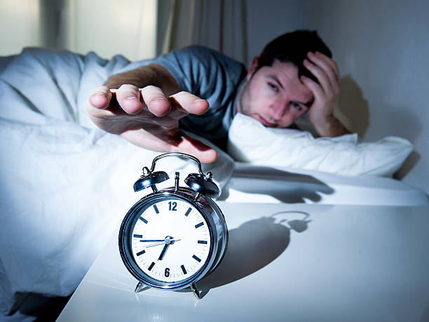 istock sleeping man disturbed by alarm clock early morning 466023827