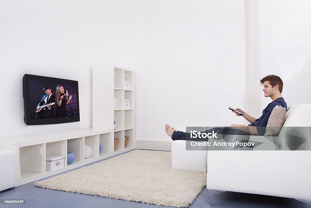 Man Watching Television Young Man Sitting On Couch Watching Television Side View Stock Photo