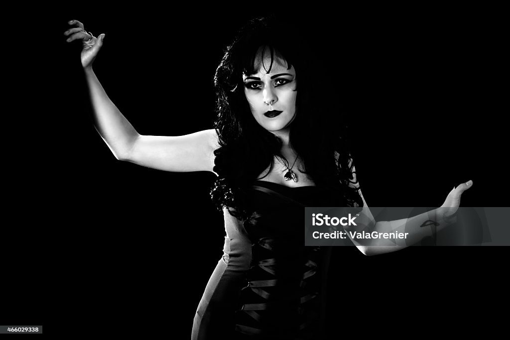 B&W high contrast image of young woman holding curtains back. High contrast B&W horizontal studio shot on black of young woman holding back curtains, making an entrance. 20-29 Years Stock Photo