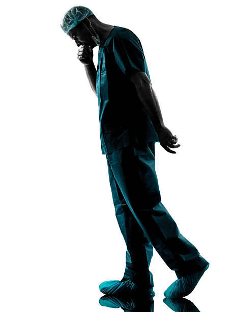 istock doctor surgeon man despair fatigue tired silhouette 466030635