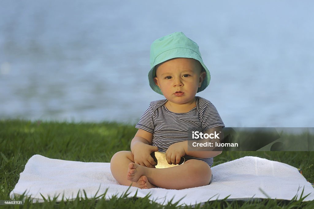 European baby holding a cell phone - 10 month old Photographed near a lake 0-11 Months Stock Photo