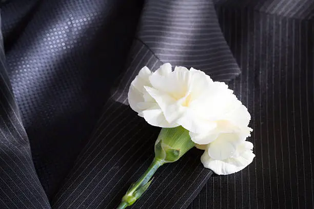 white carnation on a jacket lapel
